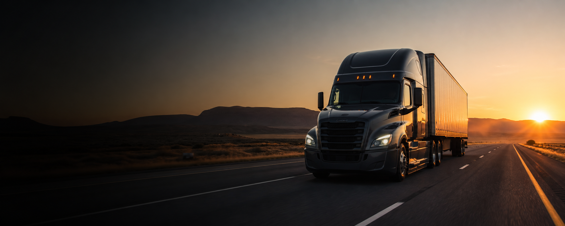 A professional semi truck traveling on an open highway at sunrise